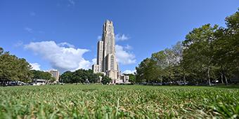 Caethdral of Learning at Pitt as seen behind a long, grassy lawn