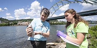 Faculty member doing research on river with student