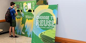 sign reading "Choose to Reuse with Reusable Containers" promoting sustainable dining options 