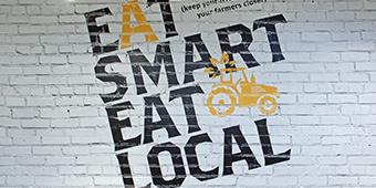 painted wall signage reading Eat Smart Eat Local