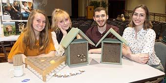 students showing bee-house construction samples